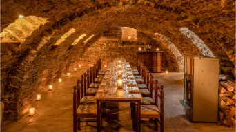 Tische und Stühle mit Kerzen für 16 Personen im Gewölbekeller. Landhaus Odaia.